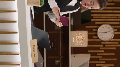 Hotel Clerk Checks Passport at Front Desk
