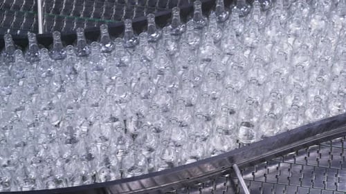 Bottles on Conveyor Belt in Factory. Bottle Manufacturing Technology in Industrial Factory