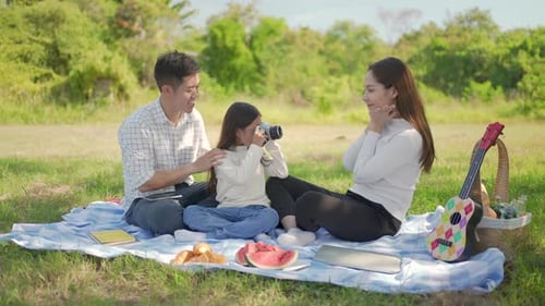 Family Picnic with Vintage Camera in Grassy Field