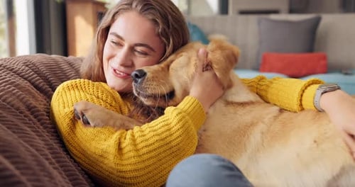 Woman Hugging Golden Retriever on Sofa at Home