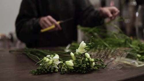 Flower Arranger Trimming Stems in Floral Shop