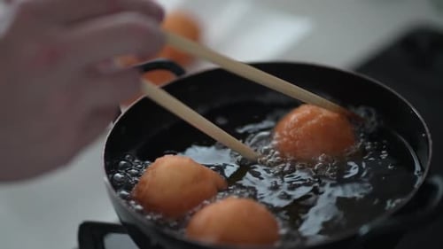 Dough Balls Deep Frying in Dark Pot