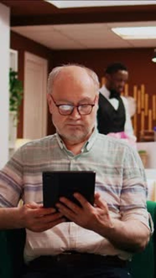 Vertical Video Older Man Checks Tablet Connection