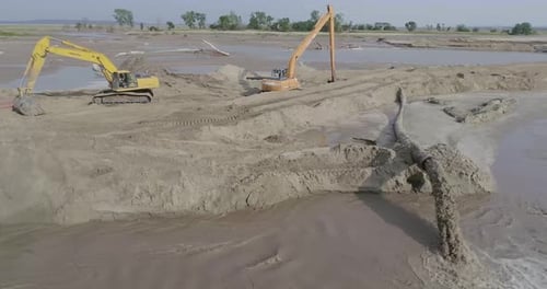 Sand vom Ende des Baggers abpumpen.