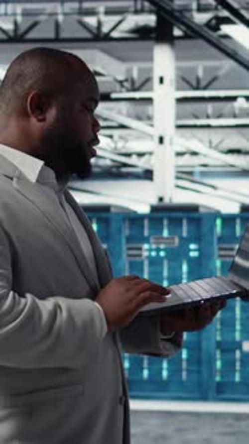 Ingénieur d'infrastructure de salle de serveurs vidéo verticale écrivant des scripts de flux de travail automatisés à l'aide d'un logiciel