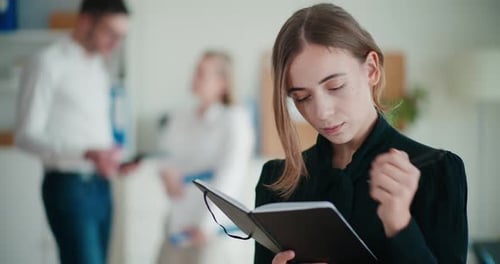 Businesswoman Taking Notes in a Bright Office