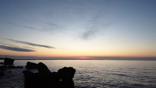Beautiful vibrant high contrast sunset low altitude flyover over the Karosta war port concrete coast