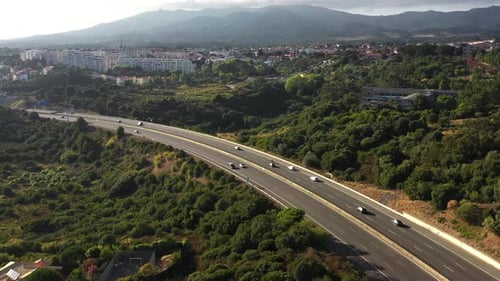 Drohnenaufnahme von Fahrzeugen, die sich auf der Autobahn inmitten grüner Landschaft bewegen