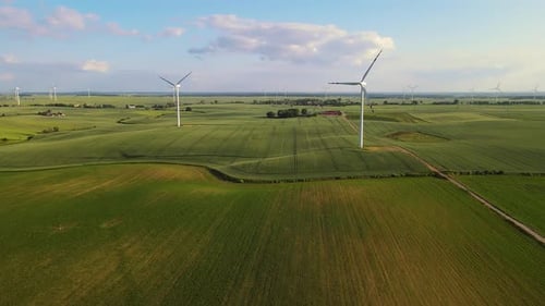 Wind Turbines Rotating in Lush Green Field