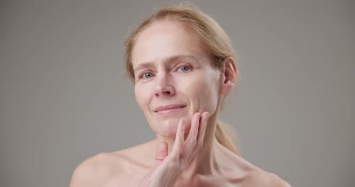 Woman Caressing Her Face Gently in Studio