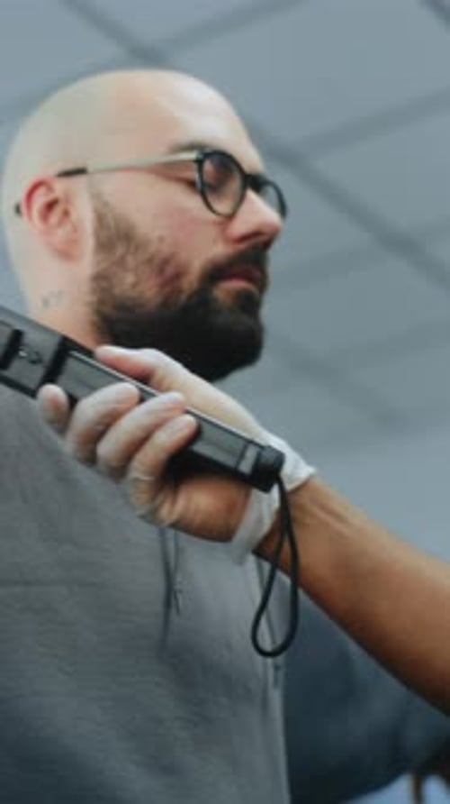 Airport Terminal Security Officer Inspects Man Body Using Metal Detector