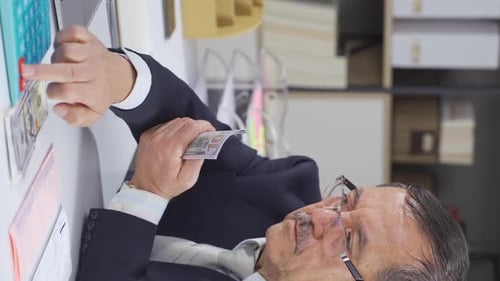 Adult Man Counts Money in Office