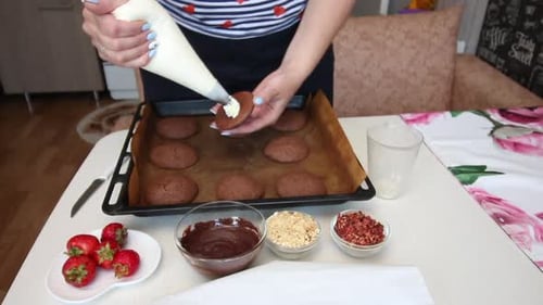 Woman Decorates Cookies with Cream and Chocolate