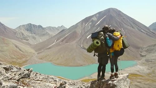 Couple Of Hikers Stand On Viewpoint Over Lake