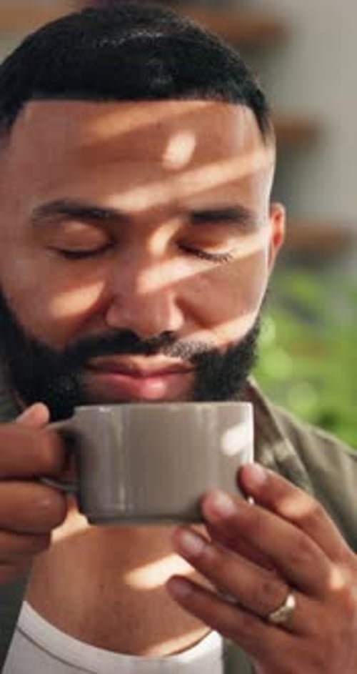 Man Drinks Coffee and Smiles Inside