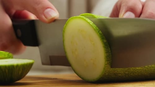 Cutting Green Zucchini on Wooden Desk with Knife Closeup Macro Slicing Squash Woman Hand Cut