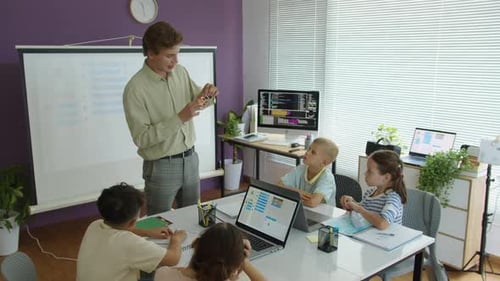 Tutor Showing Innovative Robot to Group of Kids at School