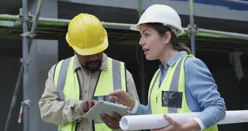 4k video footage of a man and woman using a digital tablet while working at a construction site