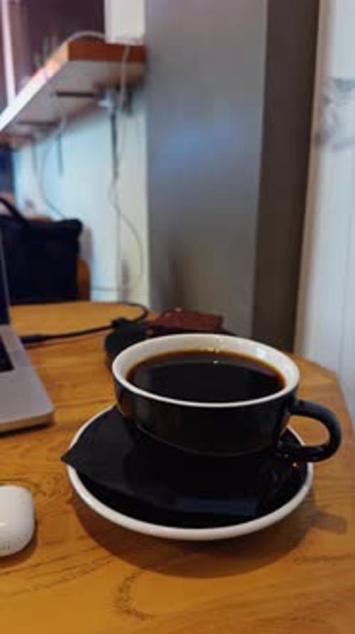 A Coffee Cup Placed on a Wooden Table Accompanied By Laptop and Various Accessories for your