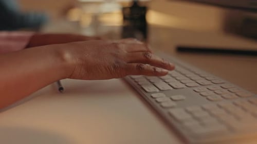 Hands typing at night, keyboard and black woman working overtime, web search work on pc
