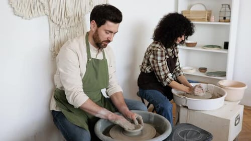 Homme et femme potiers fabriquant des vases en argile sur des roues de potier