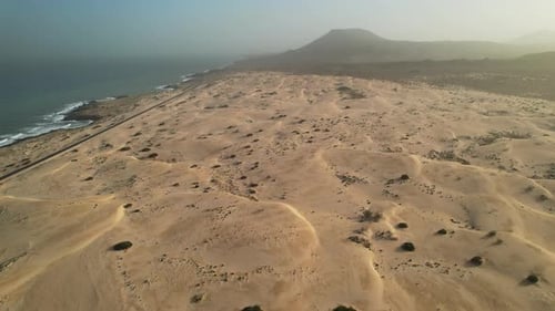 Aerial of famous scenic desert sand dunes along ocean coast at Fuerteventura