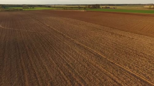 Sowing fields with tractor and seeder in dusty field aerial view