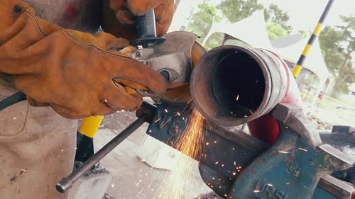 Blacksmith or welder professional, smooths steel and iron,in extreme slow motion,to make the surface