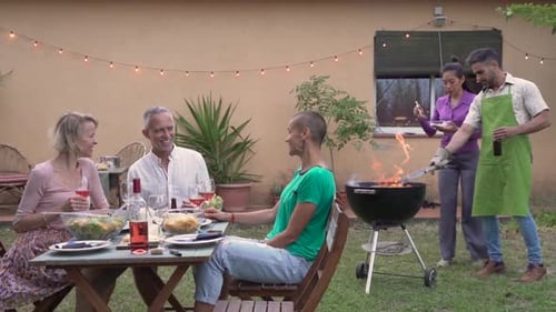 Friends Having Summer Barbecue in Backyard