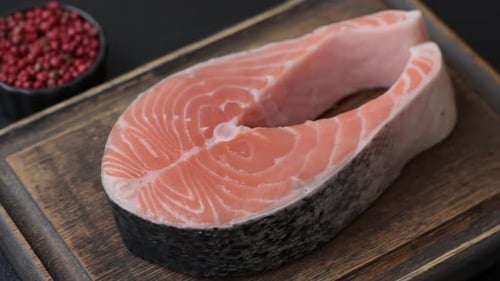 Raw Salmon Steak with Spices on Cutting Board