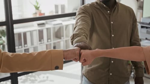 Adults bump fists in a modern office