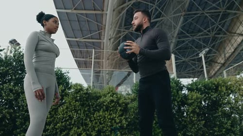 Kaukasischer Trainer demonstriert dem Auszubildenden die Medizinball-Technik