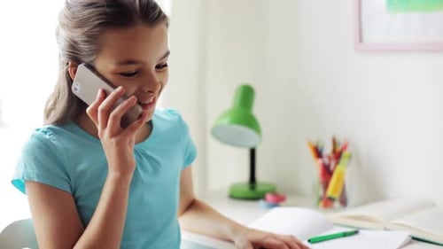 Girl Chatting on Phone While Studying at Desk
