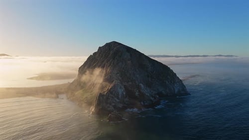 A Breathtaking and Majestic Coastal Rock Formation Enveloped in Ocean Mist at Sunrise