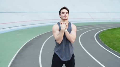 Professional Runner Warming Up At Modern Stadium. Fitness Man Stretching On Racetrack At Stadium....