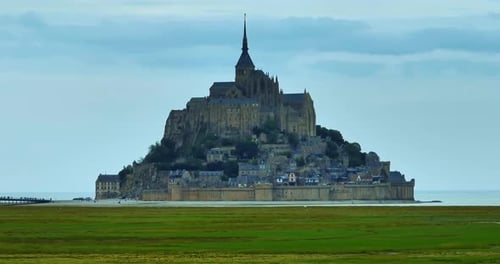 Aerial View of Mont Saint Michel A Large Flock of Sheep Grazing Against the Backdrop of Mont Saint