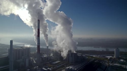 Aerial View of Smoking Industrial Plant on Sunny Day