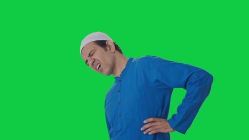 Muslim man suffering from back pain Green screen