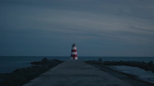 Lighthouse at the seaside by the coast at night after sunset