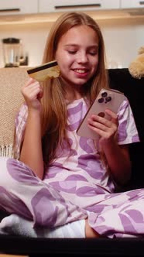 Teen girl online shopping using credit card at home