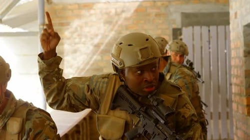 Front view of mixed-race military soldiers walking with rifles during military training 4k