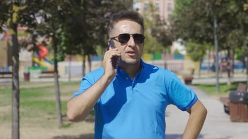 Man Talking on Phone in Urban Park