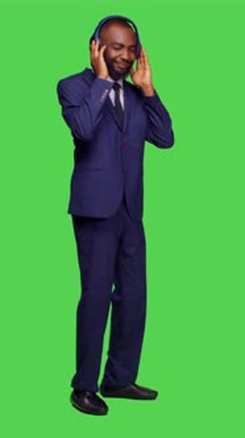 Vertical Video Side View of Male Manager Using Headset Listening to Music on Camera