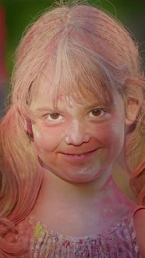 Vertical Video Little Girl in Colorful Paint at Holi Festival Happy and Contented Looking at Camera