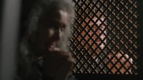 Priest Speaking behind Lattice Screen during Confession of Senior Woman