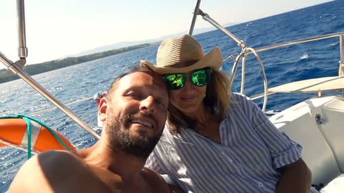 Couple sailing on sunny blue water in Greece
