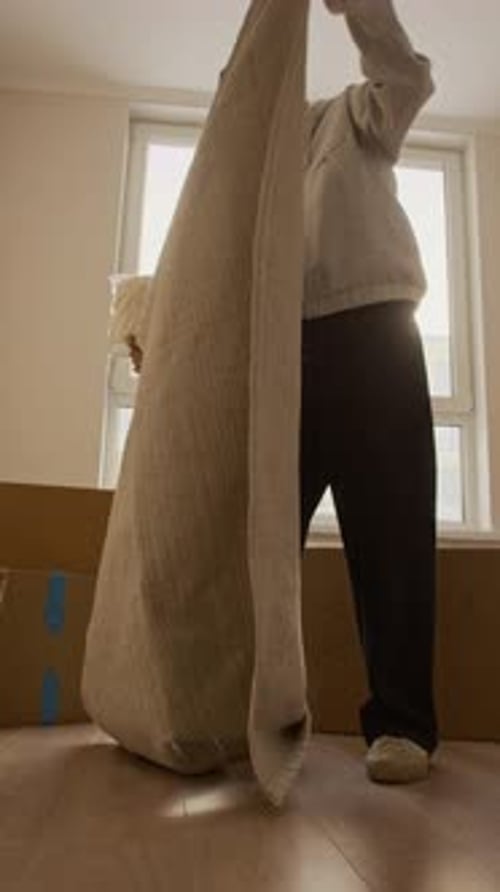 Homme installant un tapis dans un appartement lumineux pendant le déménagement