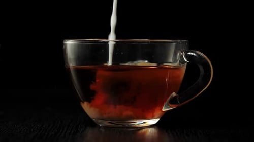 Cream Added to Tea in a Clear Glass Cup