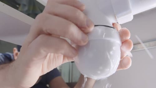 Um encanador corrige um vazamento em um sistema de drenagem de pia