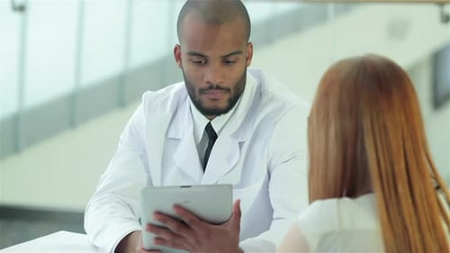 Doctor Discusses Tablet with Patient in Clinic